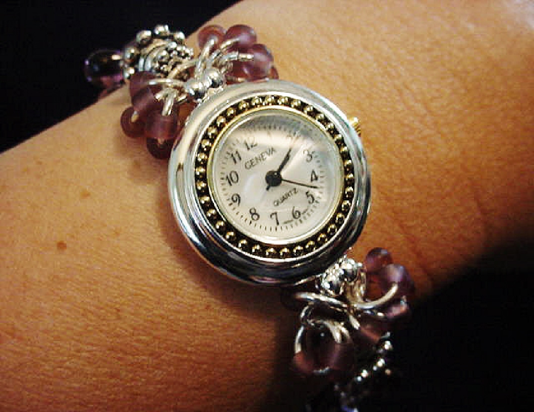 Handcrafted Jewelry Pink & Purple Watch-Handcrafted with Drop Glass Purple & Pink beads. Embellished with Silver plated findings and details. Stretch cord is used for watch band. Round silver and gold details watch face.White Opalescent Geneva sphere. Quartz function and mechanical system. Stainless Steel back and is water resistant.Beautiful and Elegant!